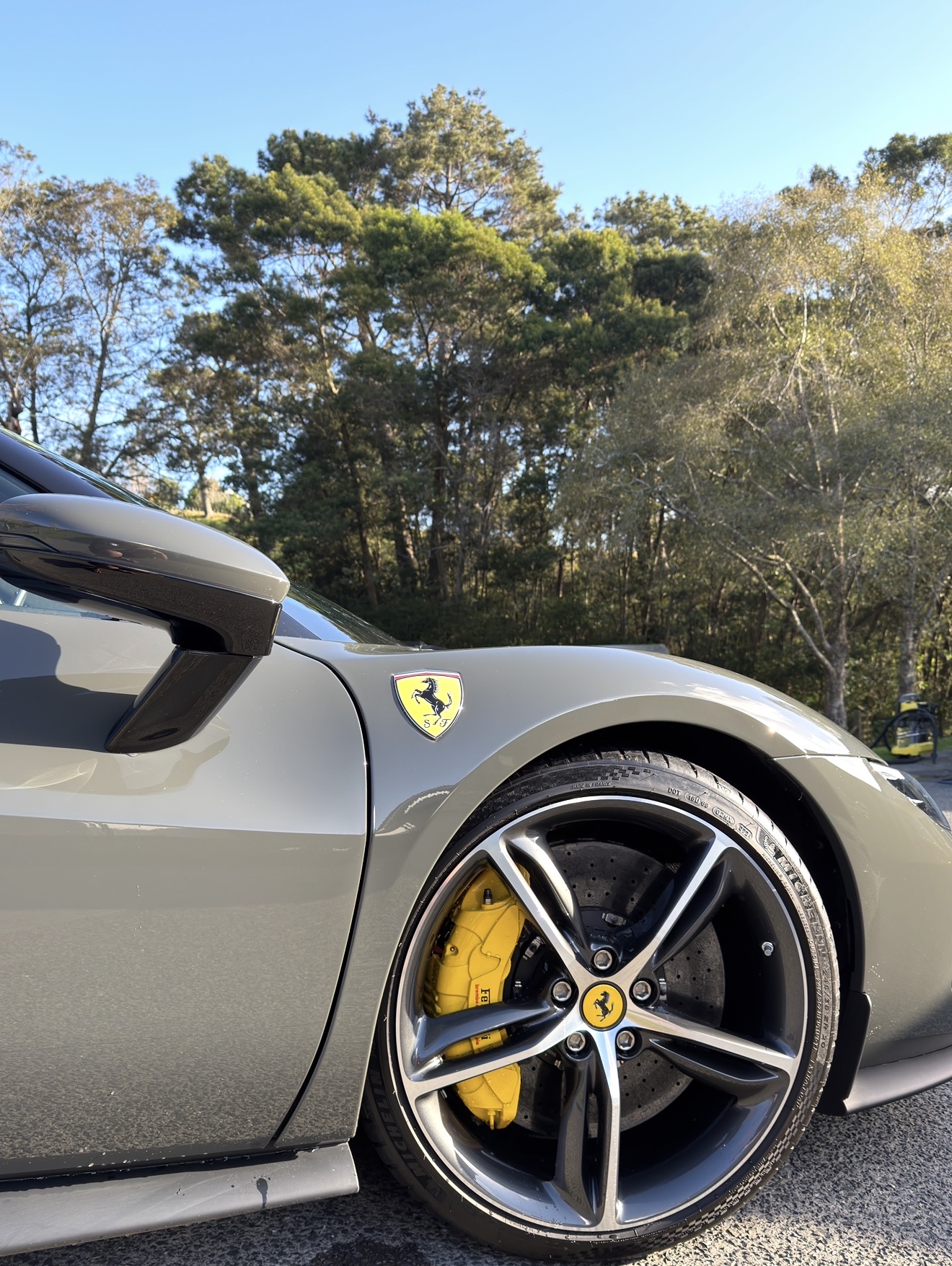 Grey Ferrari front wheel and yellow caliper.